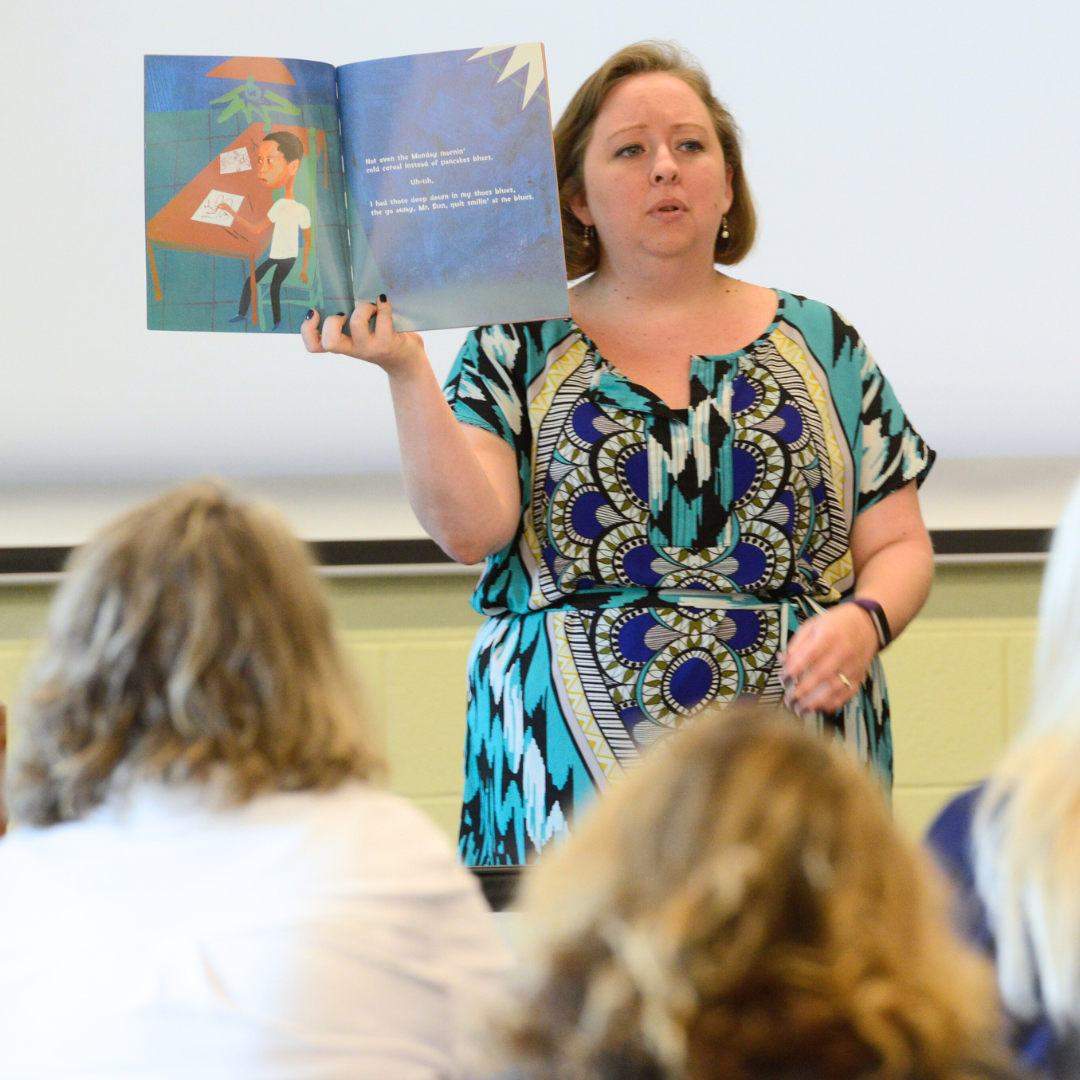 A facilitator leads a group of teachers in a reading exercise