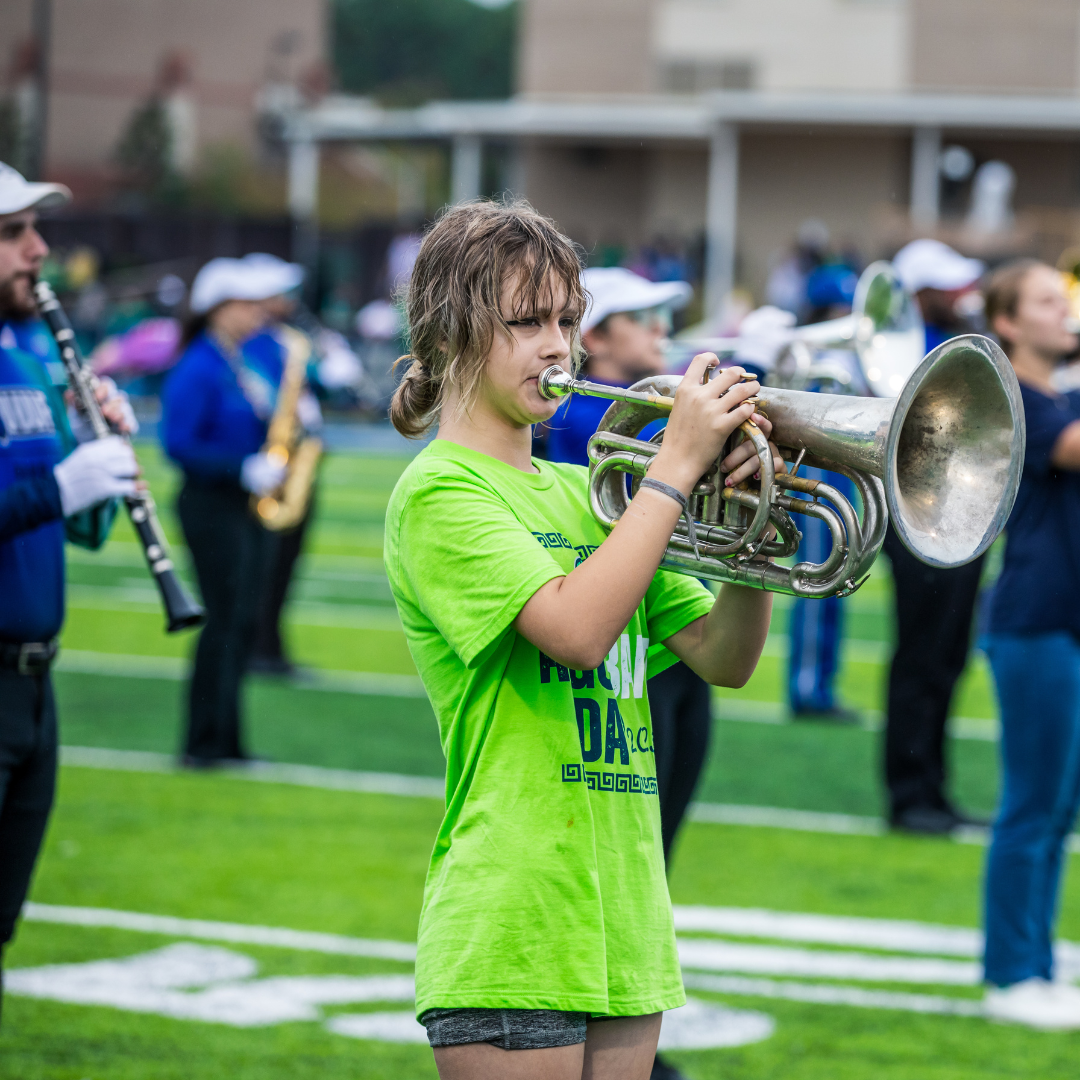 A local high school student plays with Argo band during a football game.