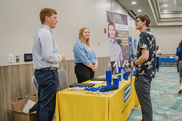 Employers talking to a student at a career fair