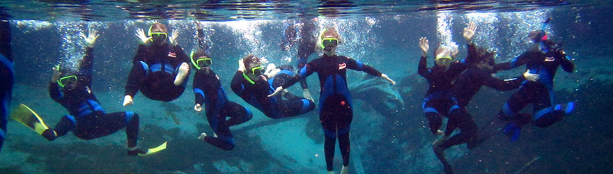 Students snorkeling underwater and posing for the camera