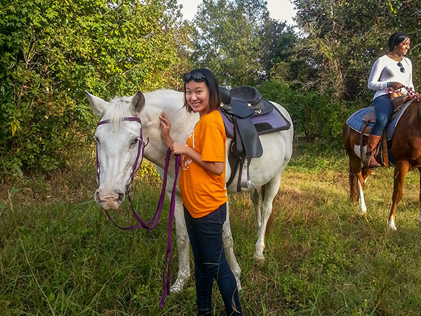 Student posing next to their horse 