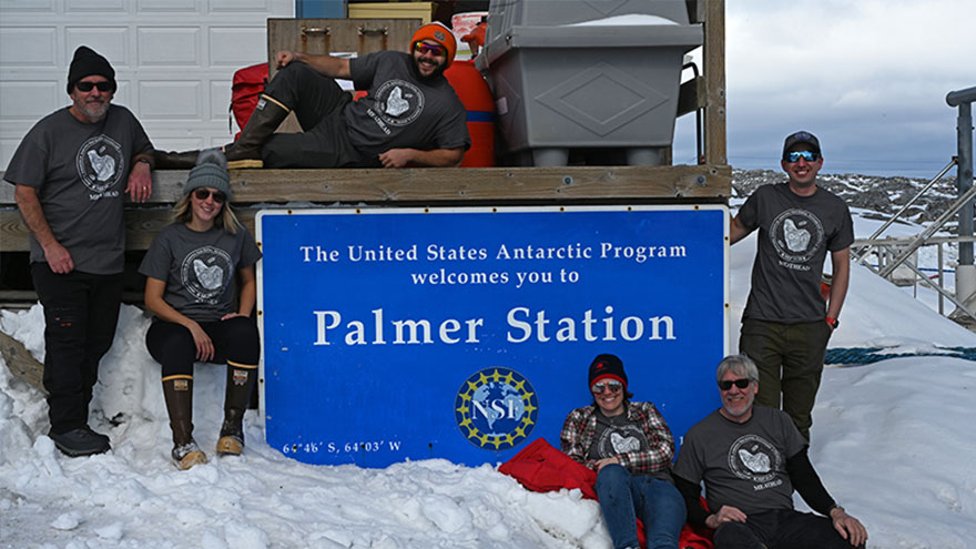 Group photo in front of the Palmer Station Welcome sign