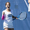 UWF alumni Heather Mixon cheering and holding a tennis racquet during a UWF tennis match.