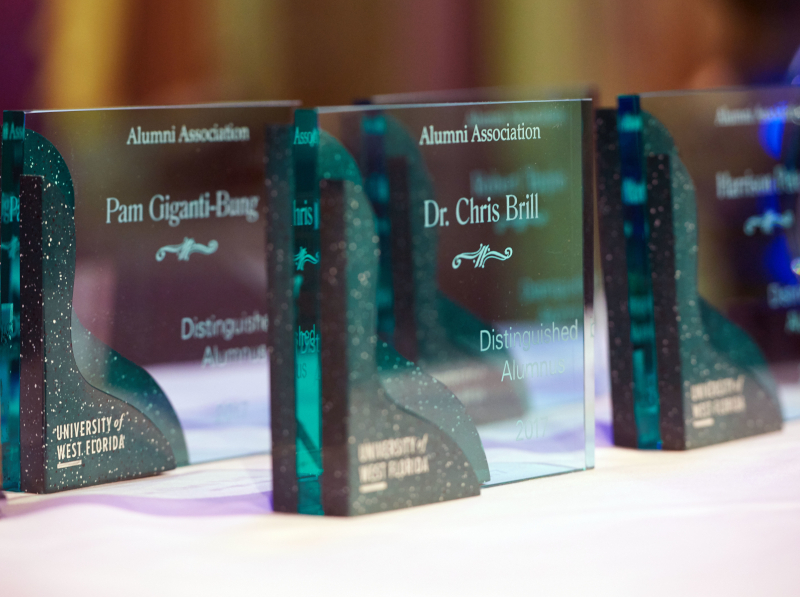 Green, glass rectangular awards are displayed on a table before the 2017 Alumni Awards ceremony.