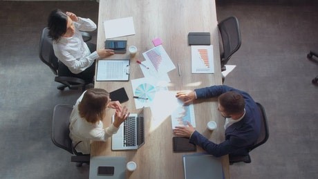 Image of three people working around a desk