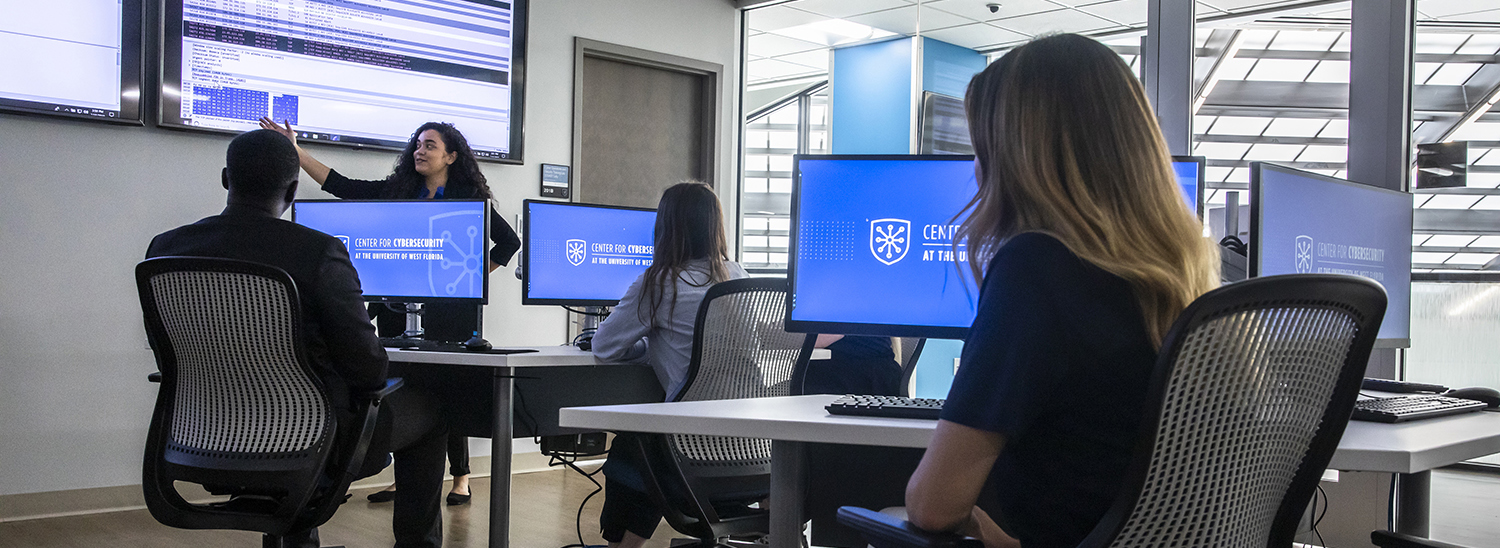 Students and professor working in cybersecurity computer lab