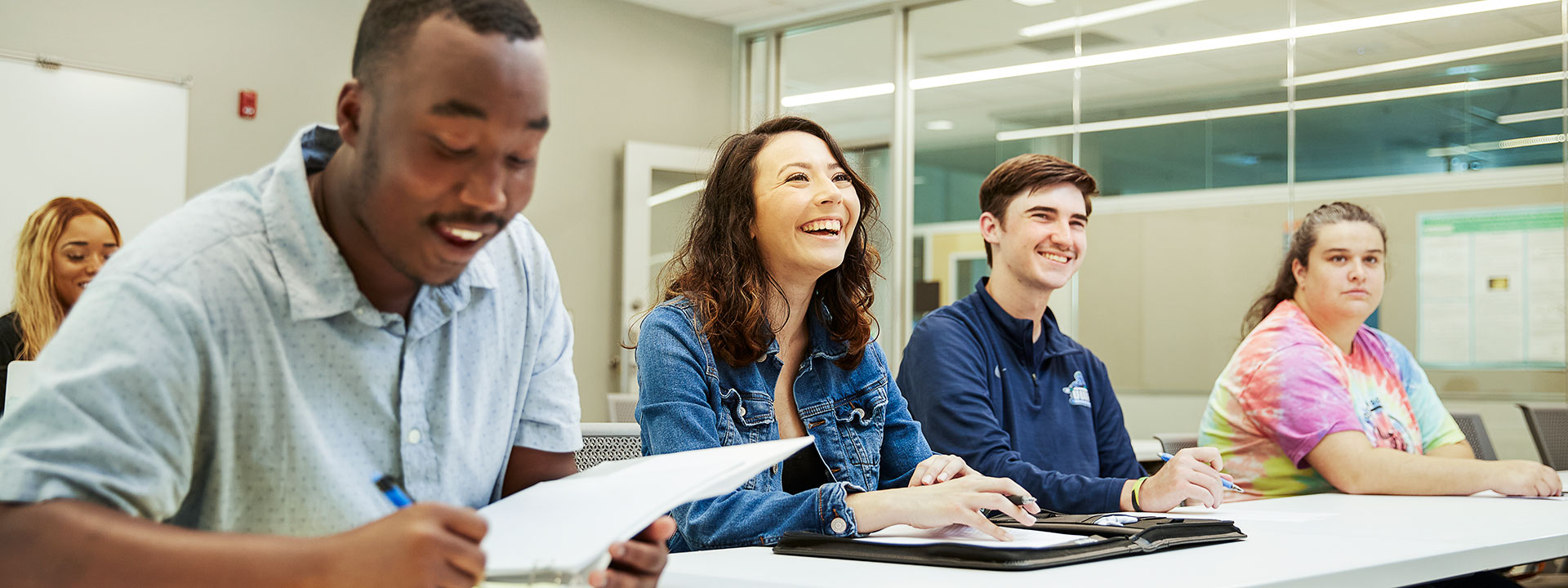 four uwf students in a row in class looking off camera