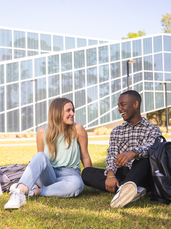 Mobile - 2 students sitting on grass