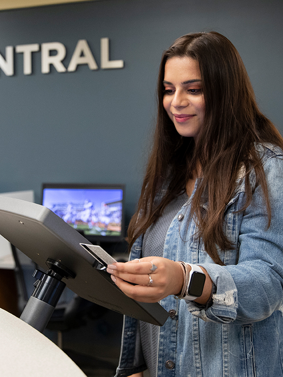 A student swiping her Nautilus Card at the Argo Central front desk