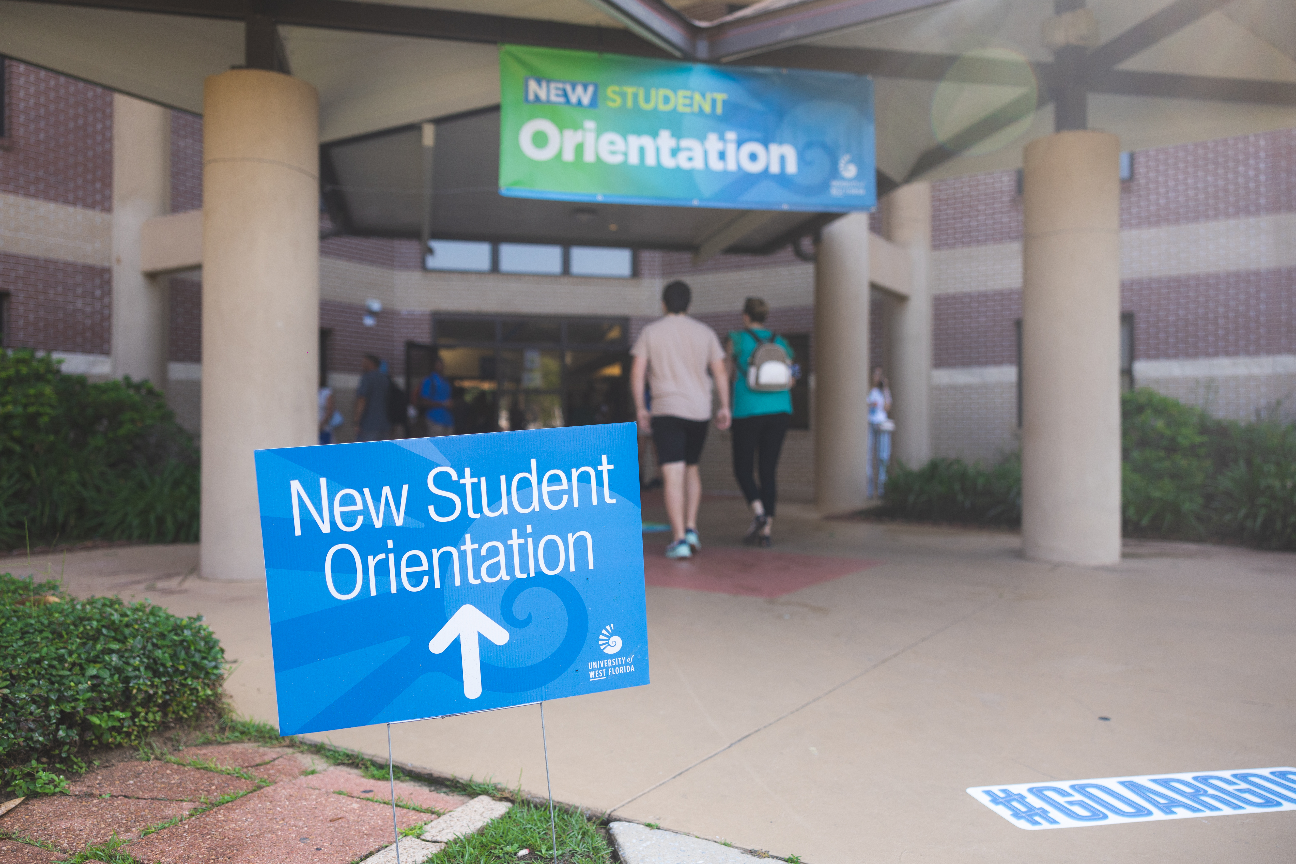 Students entering Martin Hall with sign directing to New Student Orientation