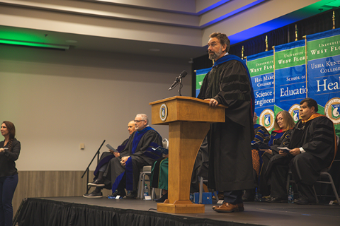 Provost Kuhl speaking at a podium on stage