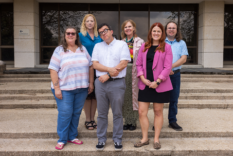 A group of employees standing on stairs outdoors