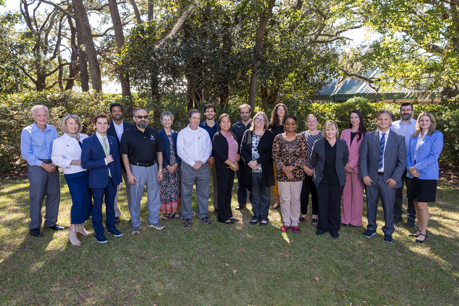 Faculty Senate stands under the shade of a tree.