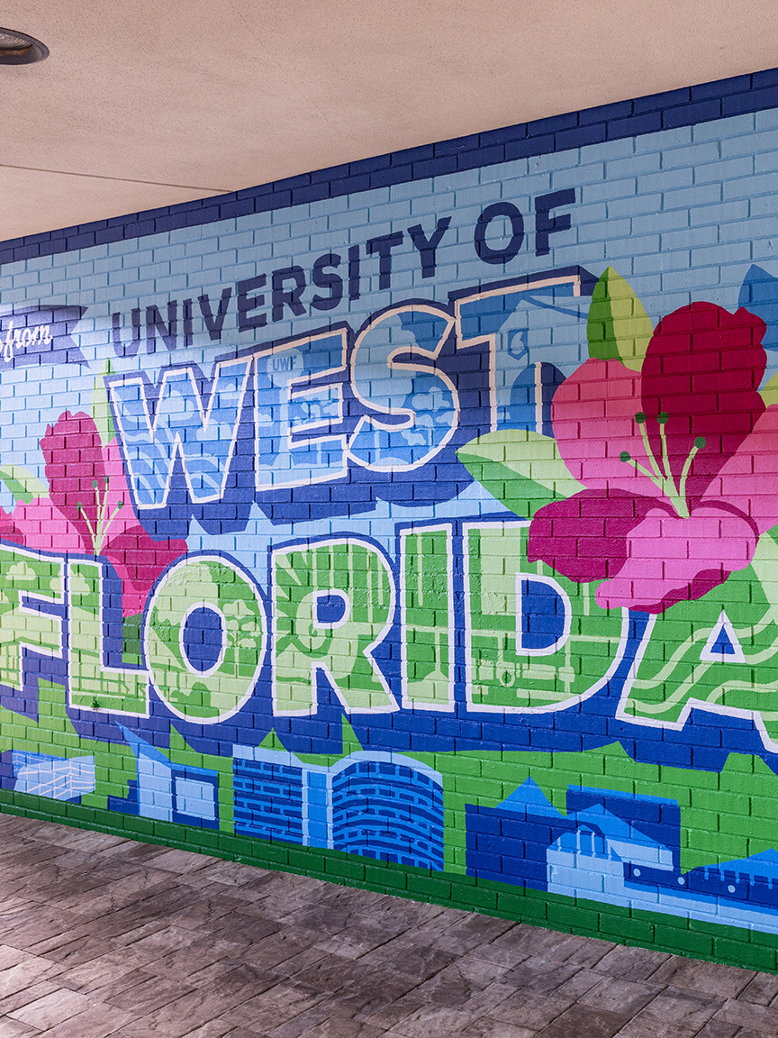A postcard-style mural with Greetings from University of West Florida featuring two large pink flowers.