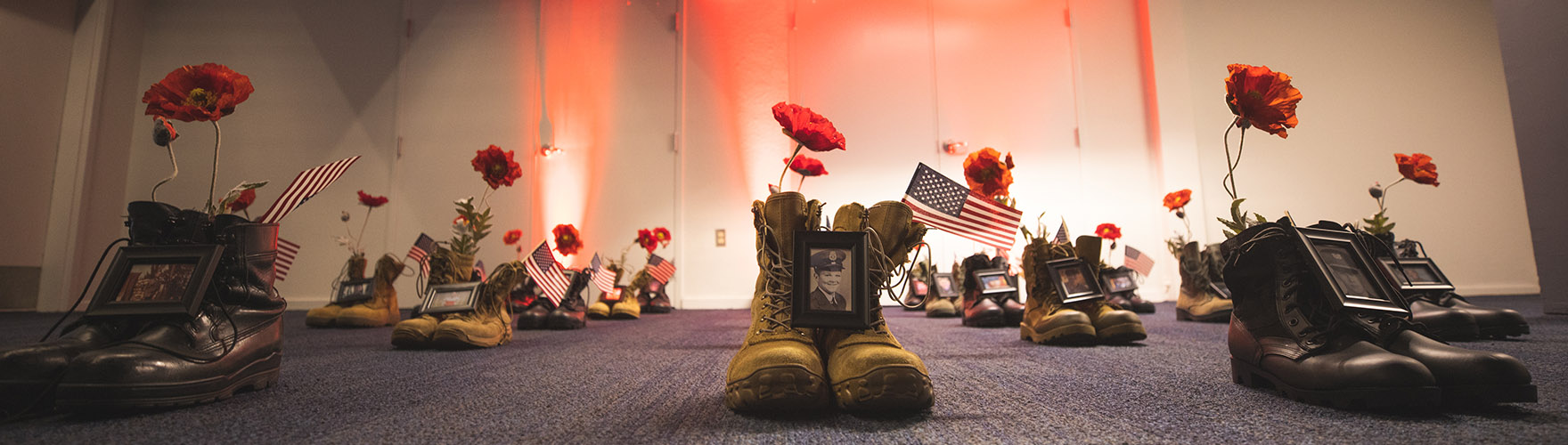 A Memorial Day display of boots, photos, and flowers honors those lost.
