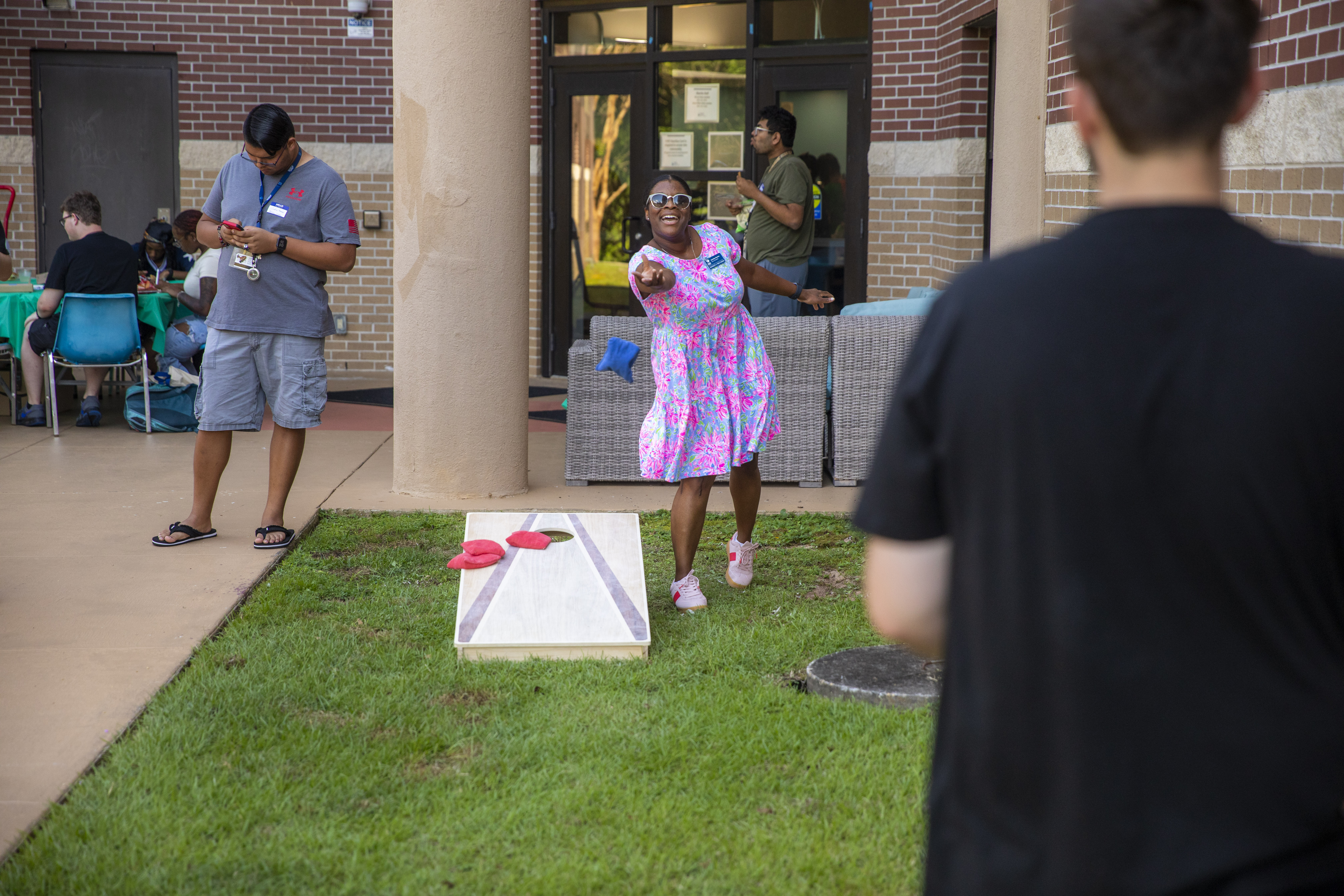 staff member playing cornhole with a student