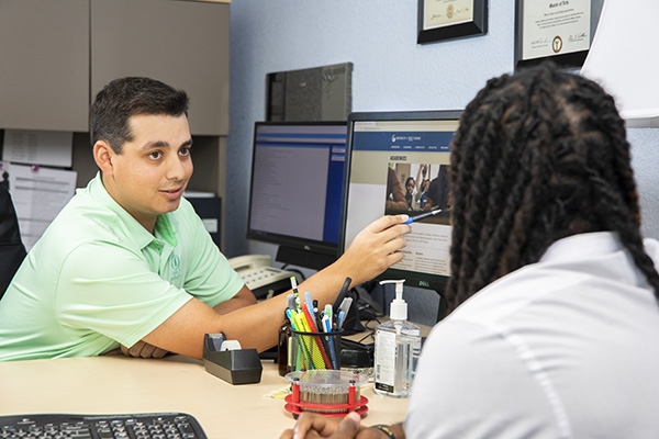 Student working with advisor on a computer.