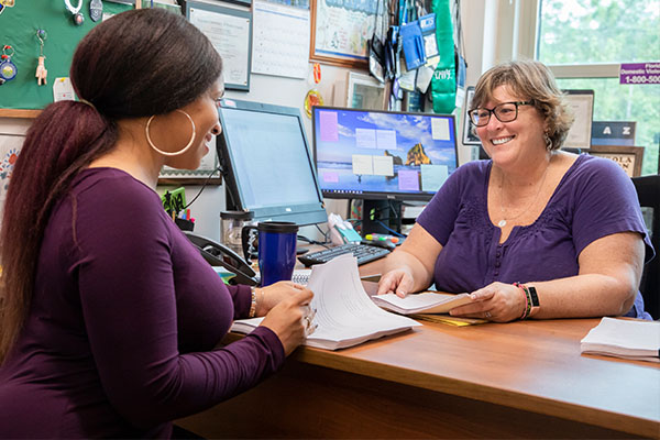 student meeting with advisor at a desk
