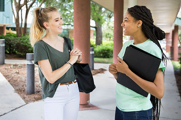 Two studens posed in front of building 21