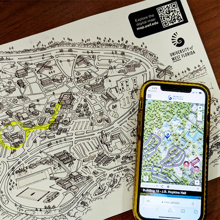 Print out of a black and white UWF map with an iPhone open to the digital UWF map on top