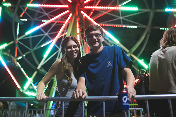 Students standing in front of a Ferris Wheel