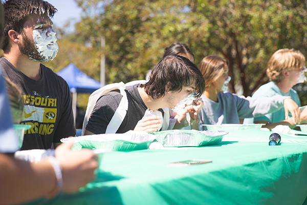 students competing eating a whipped creme pie