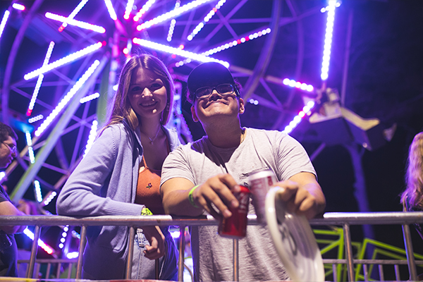 students in line to ride a CAB after dark ferris wheel