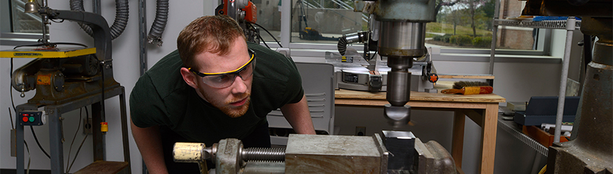 West Florida student uses a mill machine in the fabrication lab.
