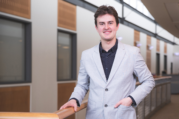 A student in professional attire with a hand on a handrail in Building 76A on the UWF Pensacola campus.