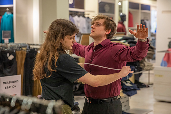 staff member measuring student during suit it up event