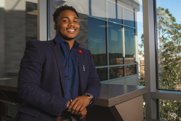 Student standing confidently in suit