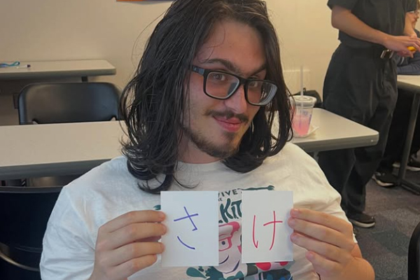 Student showing cards in Japanese for sake