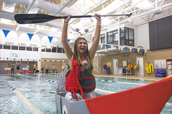 student finishing first in cardboard boat race