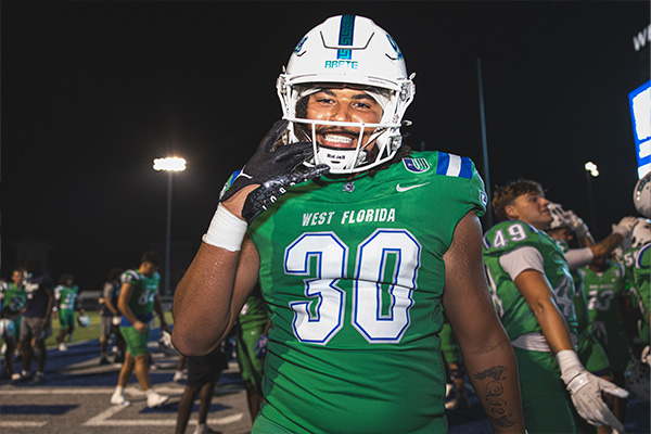 Football player holding up a W for Win