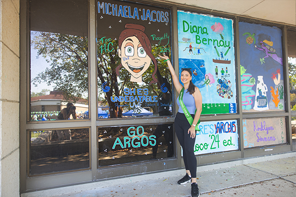 student standing in front of window decorated for Homecoming