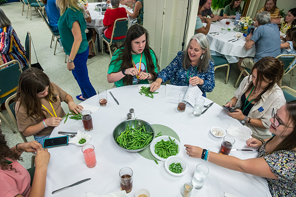 People sitting around a table working with beans