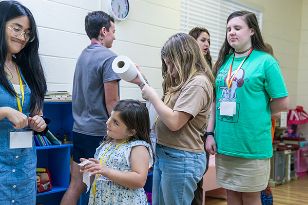 Child talking to a young adult while standing in line