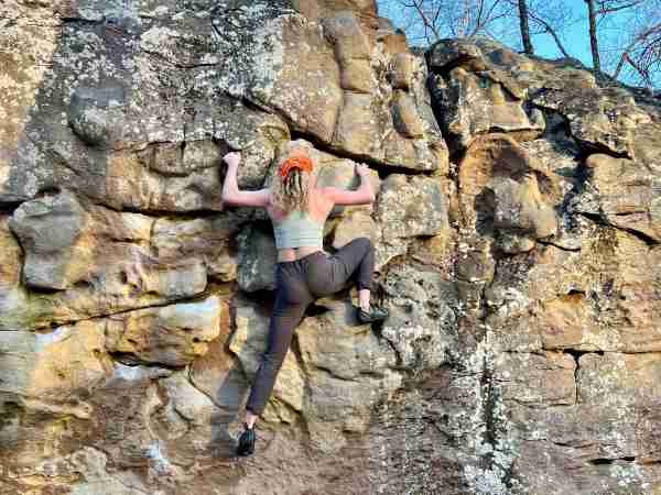 Student climbing a rock face.