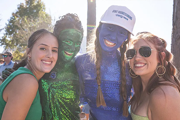 Students posing in blue and green for homecoming
