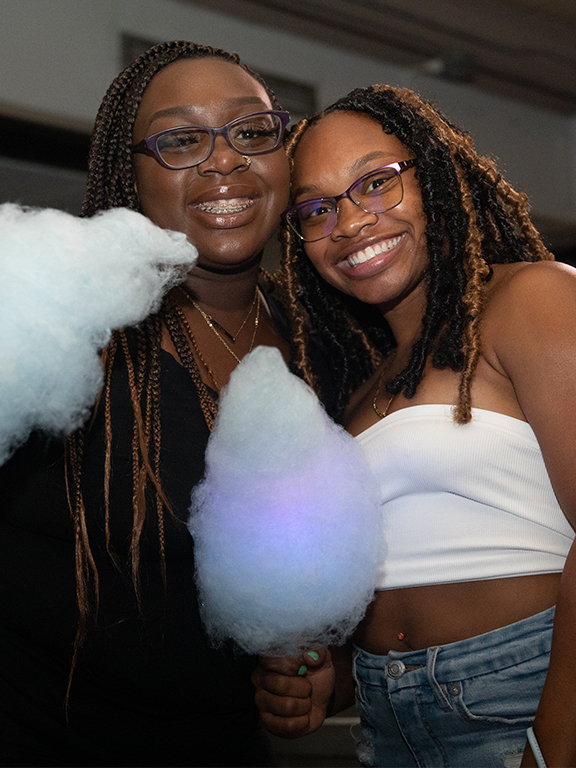 Two students smiling with cotton candy