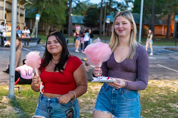 students holding cotton candy at campus event