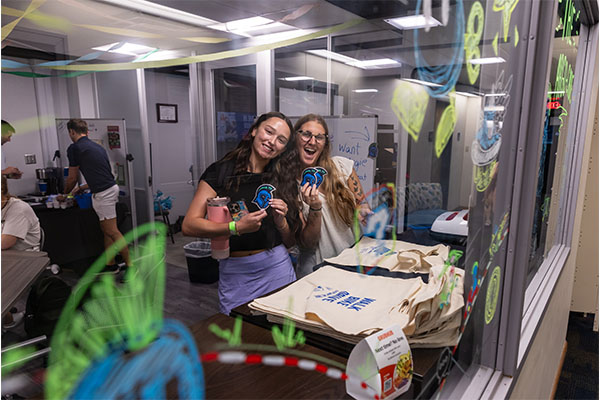 Staff and Student posing with craft in the Hub