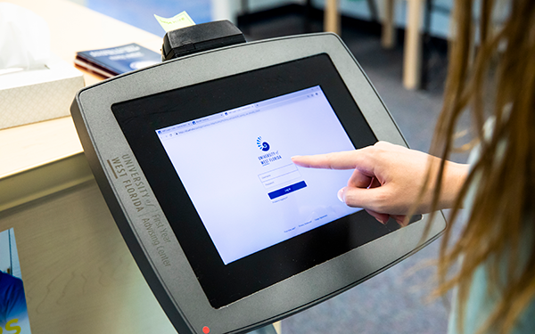 student checking into a kiosk at a front desk