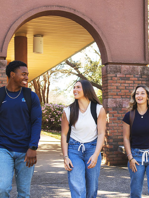 three students walking one sidewalk
