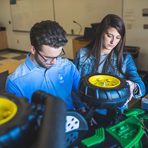 two engineering students working on an assistive vehicle