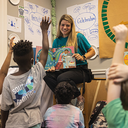 teacher reading a book to students