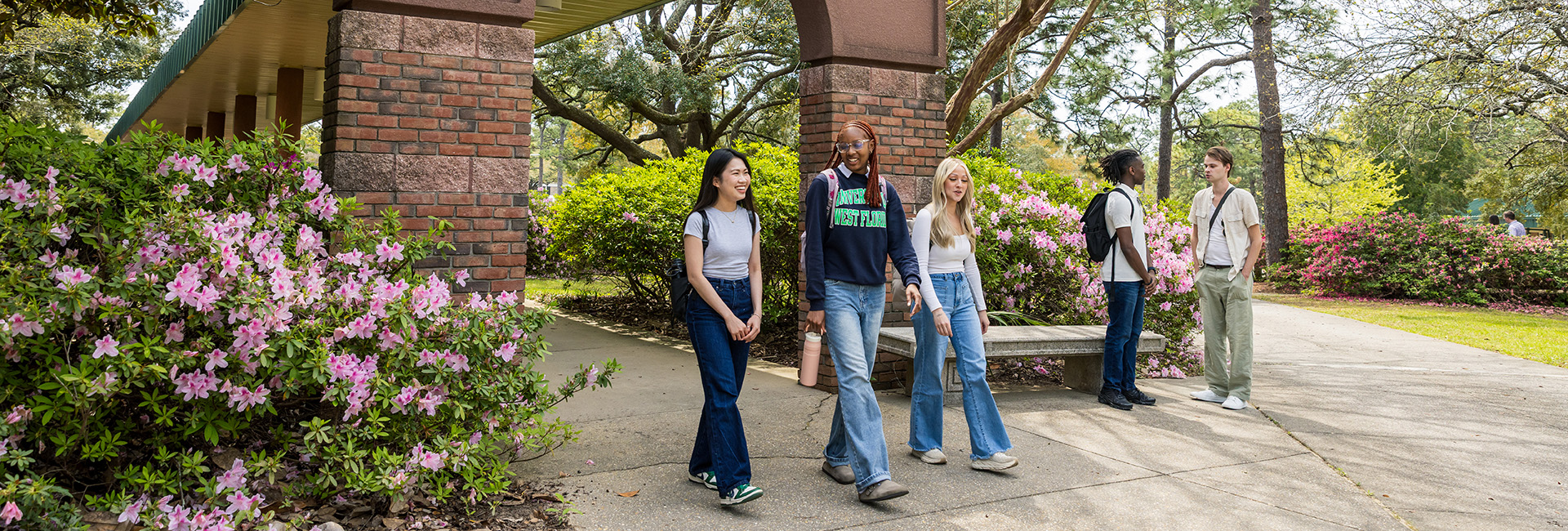 Students walk near the Canto al Sol arch near Building 21.