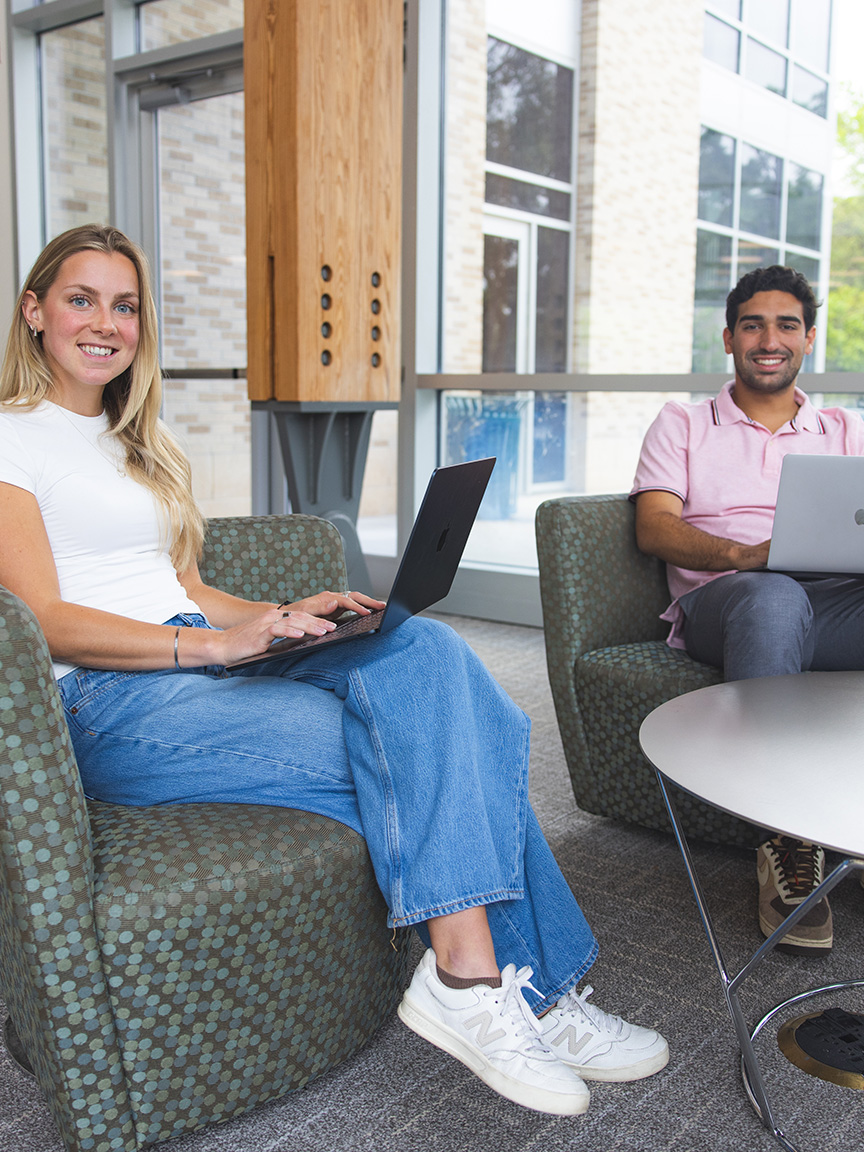 Two graduate students use laptops in the Lewis Bear Jr. College of Business.