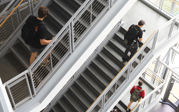 Students walk through the stairwell in Building 4.