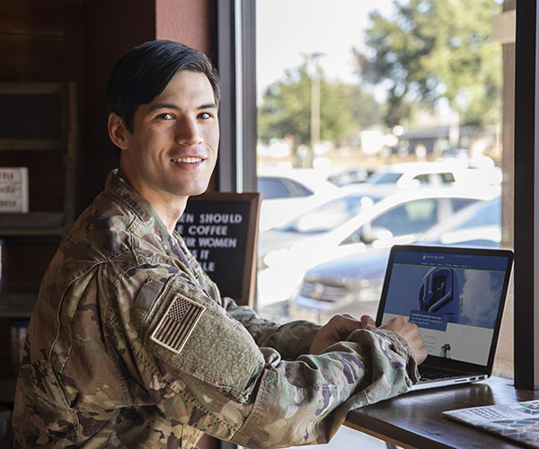 military student working on a laptop